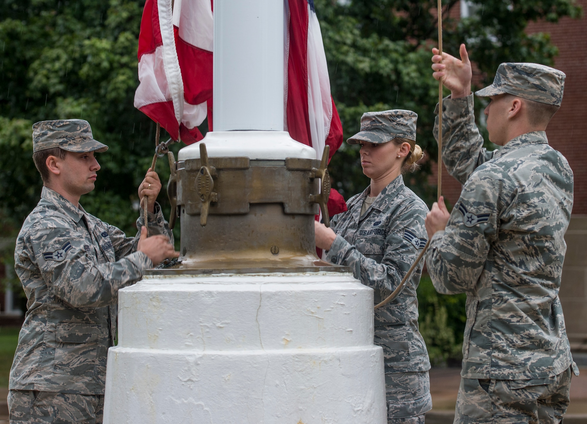 Airman 1st Class Brandon Hobbs, Senior Airman Rachel Ollie, and Airman 1st Class Adam Dann, all with the 375th Communications Squadron, raise the American flag in honor of Patriot Day, Scott Air Force Base, Ill., Sept. 9, 2016.  (U.S. Air Force photo/Staff Sgt. Jodi Martinez)