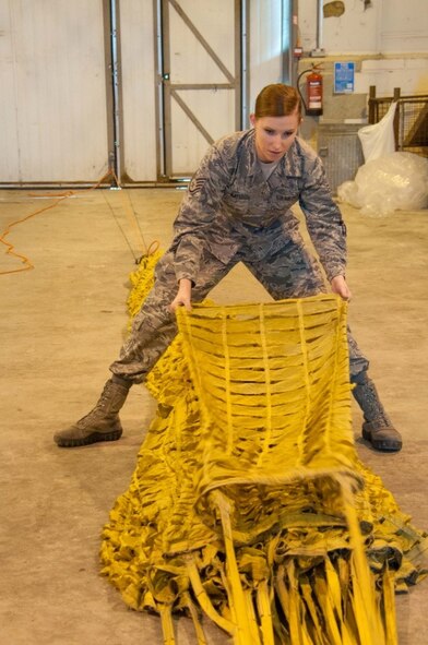 U.S. Air Force Staff Sgt. Megan Kay, 307th Bomb Wing aircraft flight equipment specialist, straightens one of 24 panels of the parachute used to slow a B52H Stratofortess after landing at Royal Air Force Fairford, England, Sept 8, 2016.    Kay is one of dozens of airmen deployed to RAF Fairford to participate in Exercise Ample Strike, a Czech Republic led, 18 nation live exercise. (U.S. Air Force photo by 1st Lt. Monique Roux/Released)