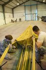 U.S. Air Force Staff Sgt. Megan Kay and Master Sgt. Curtis Downey, 307th Bomb Wing aircraft flight equipment specialists, align the 24 panels of the parachute used to slow a B52H Stratofortess during landing at Royal Air Force Fairford, England, Sept. 8 2016.  Kay and Downey are participating in Exercise Ample Strike, a Czech Republic led, 18 nation live exercise. (U.S. Air Force photo by 1st Lt. Monique Roux/Released)