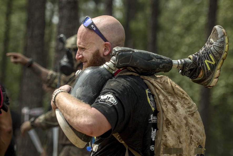A member of Operation Enduring Warrior carries a teammate’s prosthetic leg as they move from one obstacle to another during a Spartan Sprint Race at Fort Bragg, N.C..