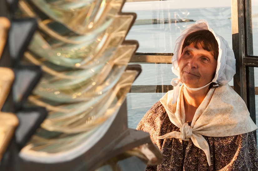 Sally Snowman, keeper of Boston Lighthouse, observes the rotation of lighthouse's 1859 Fresnel lens, Aug. 8, 2016 on Little Brewster Island in Boston Harbor. Boston Light is the last permanently staffed Coast Guard lighthouse in the country. Coast Guard photo by Petty Officer 3rd Class Andrew Barresi