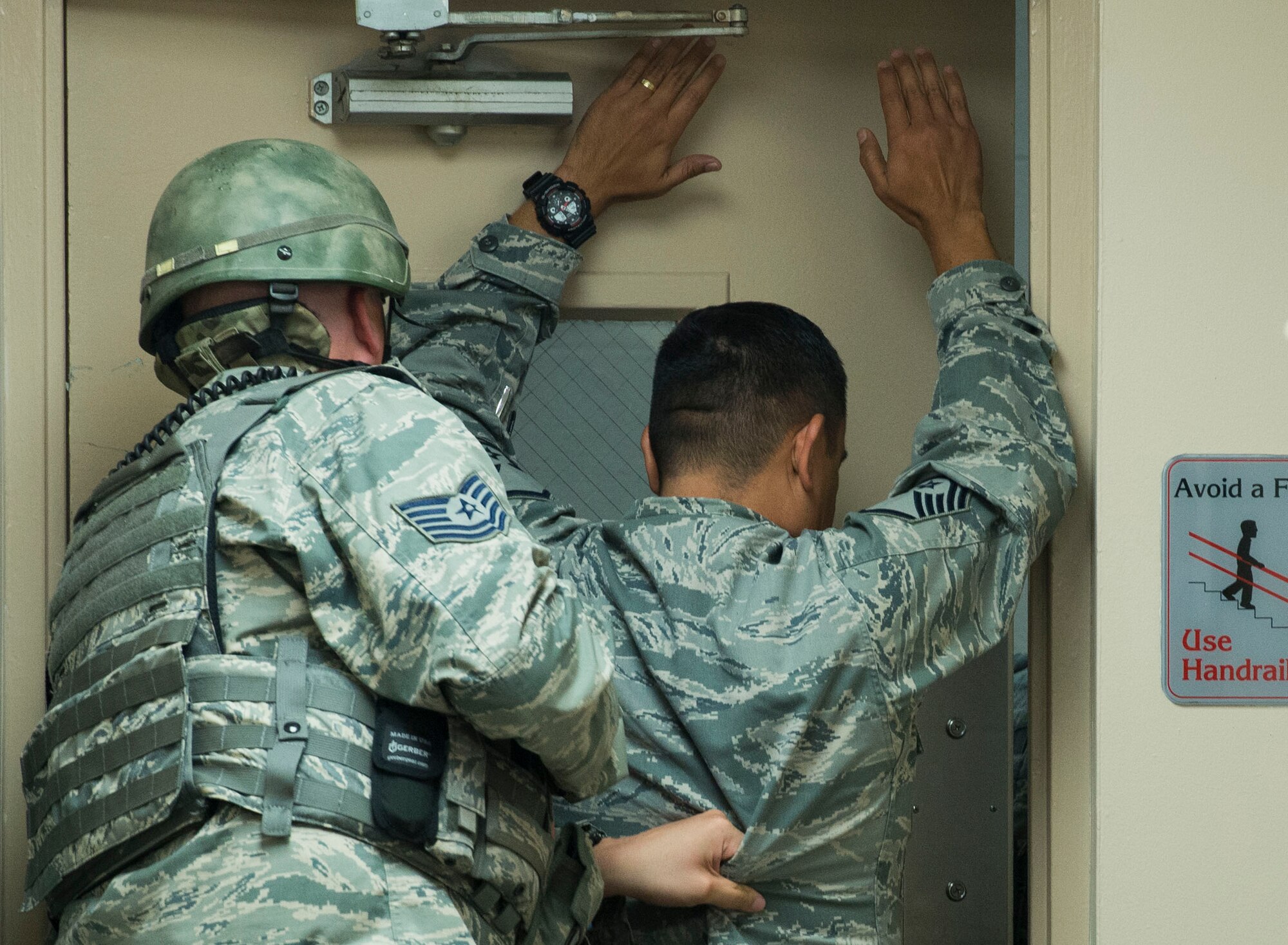 Tech. Sgt. Bryan Dell, 375th Security Forces Squadron, uses a bystander to open the door during an active shooter exercise, Scott Air Force Base, Ill., Sept. 9, 2016.  With an increase of mass shootings, the Department of Defense has trained personnel and first responders on how to respond in an active shooter situation.
