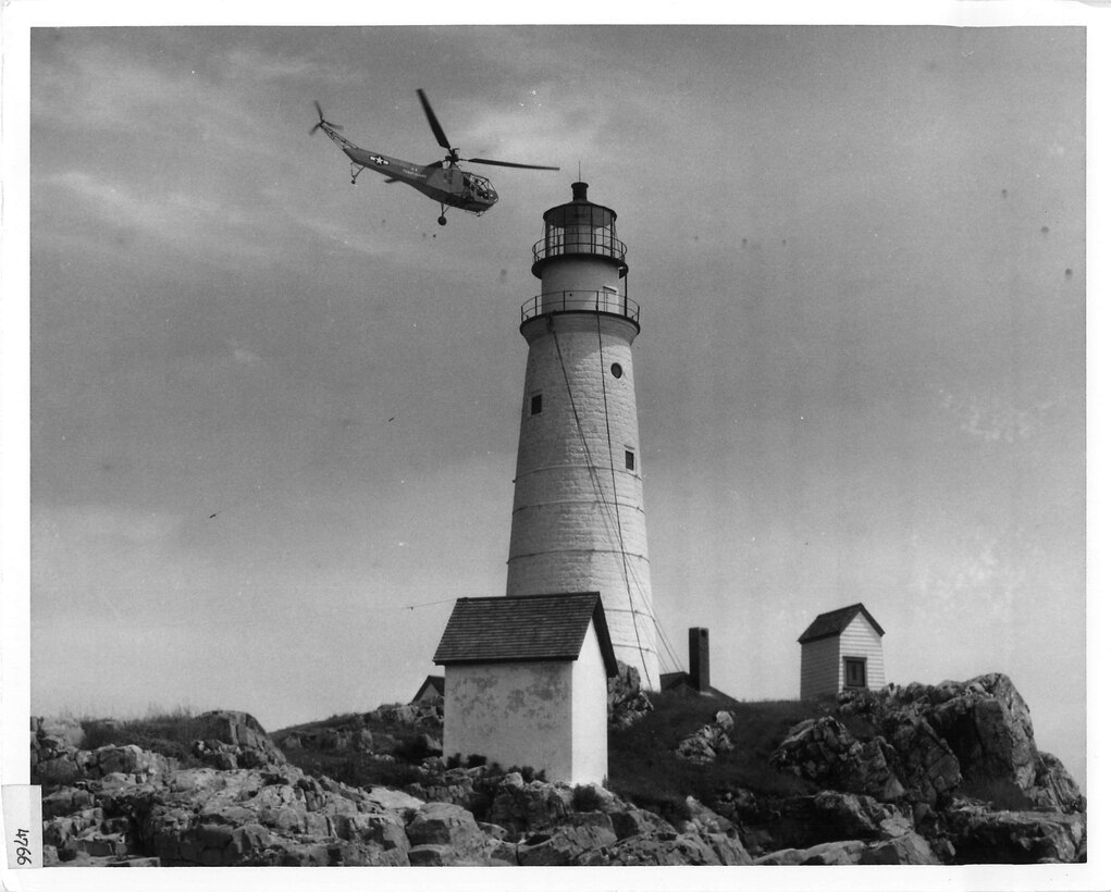 A juxtaposition of old and new, one of the Coast Guard’s newest, a Sikorsky HNS-1 helicopter, flies over Boston Light in about 1945. Coast Guard photo