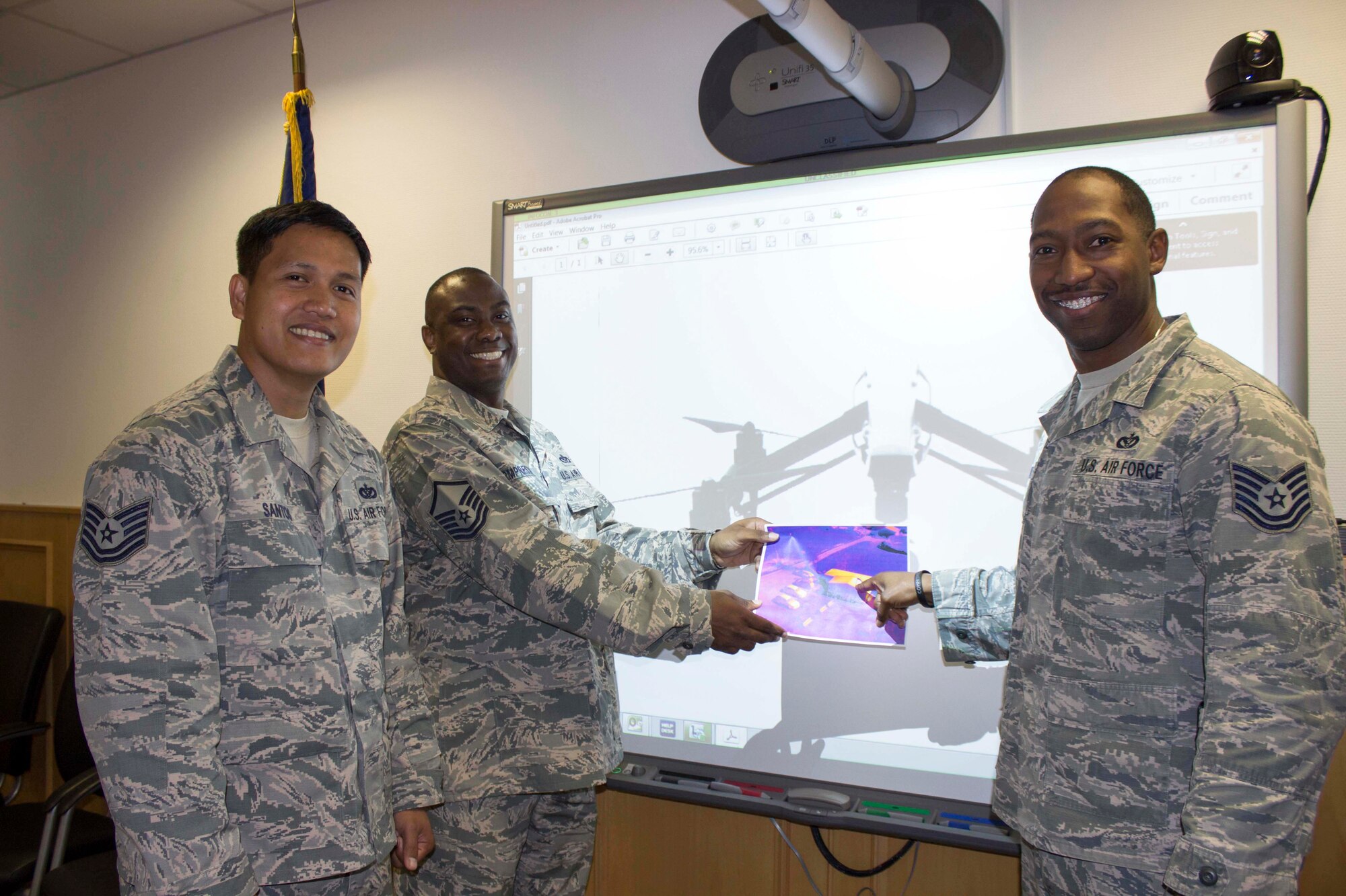 At Ramstein Air Base, Germany, (L to R) Tech. Sgt. Jeffrey Santos, Master Sgt. Sherman Armprester, and Tech. Sgt. Quentin Rawls, share an infrared photo taken with the facility assessment vehicle, or FAV, they designed for facility condition assessments. The FAVs would include thermal imaging, infrared, three battery packs, a global positioning system and a remote control. (U.S. Air Force Photo/Susan Lawson/Released)