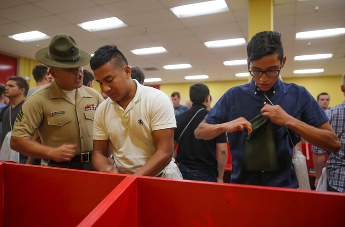 Sergeant David Alvarado, Receiving Company, Support Battalion, instructs recruits to move faster during receiving at Marine Corps Recruit Depot San Diego, Sept. 12. While recruits are on the depot, they will have drill instructors supervising them every day, everywhere they go. Annually, more than 17,000 males recruited from the Western Recruiting Region are trained at MCRD San Diego. Golf Company is scheduled to graduate Dec. 9.