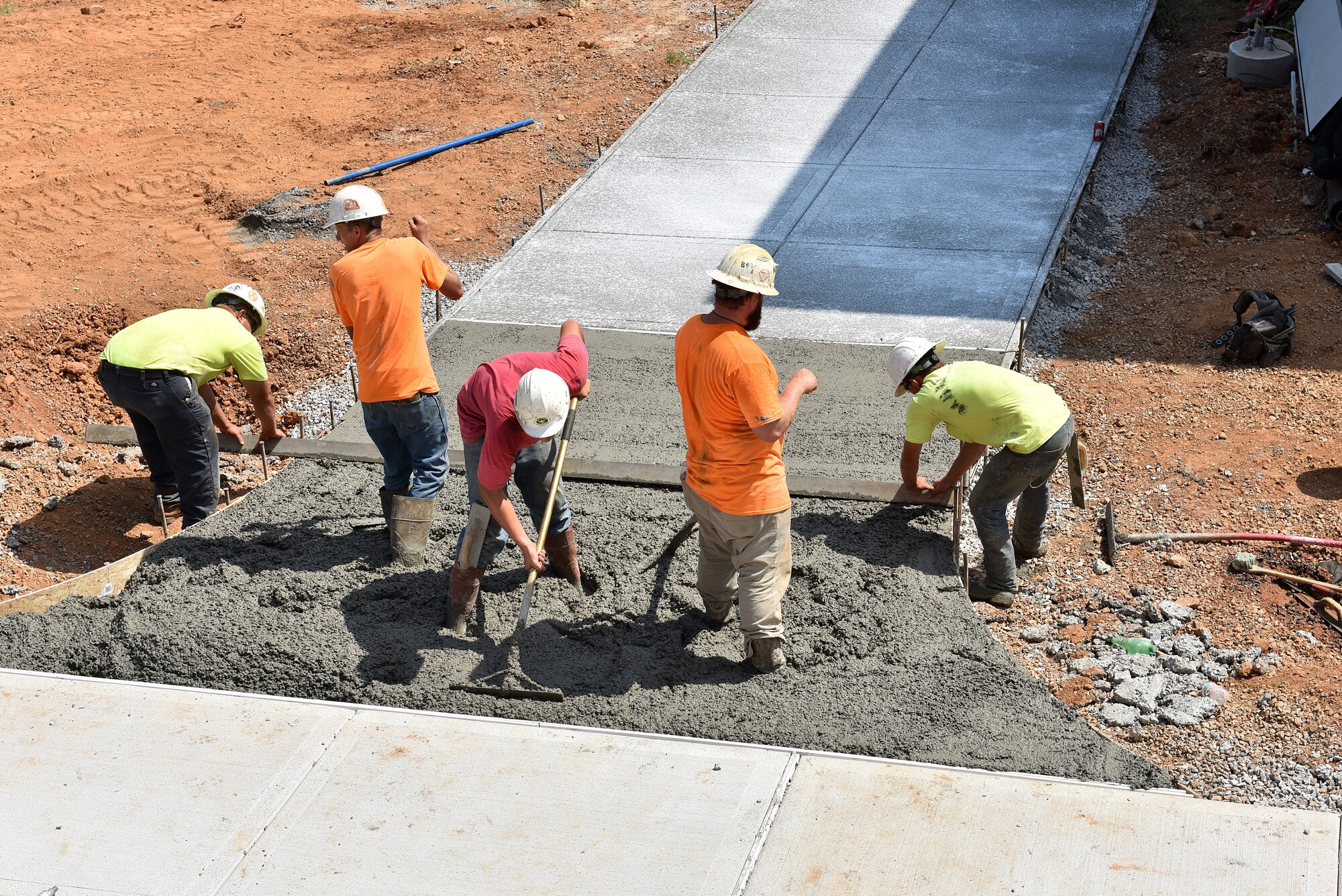 Workers connect a walkway with poured, wet cement Sept. 14, 2016, between the new facility and the older dormitory buildings on campus at the I.G. Brown Training and Education Center on McGhee Tyson Air National Guard Base in Louisville, Tenn. (U.S. Air National Guard photo by Master Sgt. Mike R. Smith/Released)