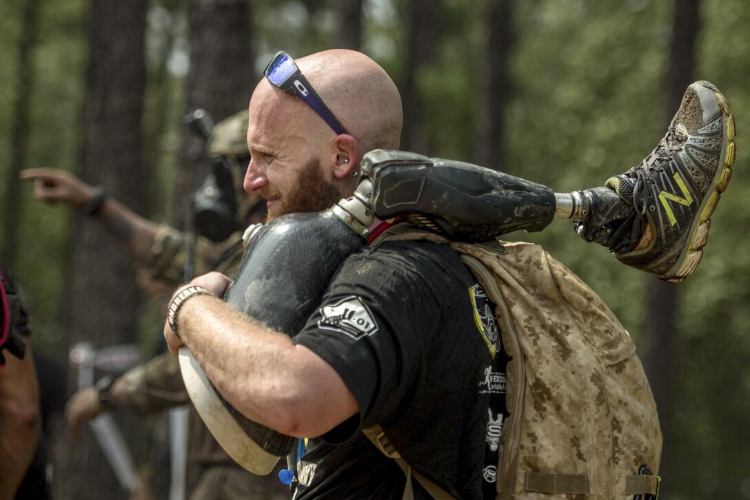 A member of Operation Enduring Warrior carries a teammate’s prosthetic leg as they move from one obstacle to another during a Spartan Sprint Race at Fort Bragg, N.C., Sept. 10, 2016. Operation Enduring Warrior is a nonprofit organization made up of current and former service members aimed at creating awareness and providing support for wounded warriors. Air Force photo by Staff Sgt. Marianique Santos