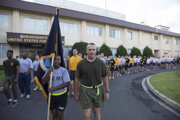 Marine Maj. Gen. Charles Chiarotti, US Forces, Japan commander, and Army 1st Sgt. Donna Cook, USFJ first sergeant, lead for the formation after completing the USFJ Command 5K Run at Yokota Air Base, Japan, Sept. 9, 2016. Over 100 service member participated in the run, which concluded with the retirement of the old USFJ colors and the unveiling of the new USFJ colors. (U.S. Air Force photo by Yasuo Osakabe/Released)