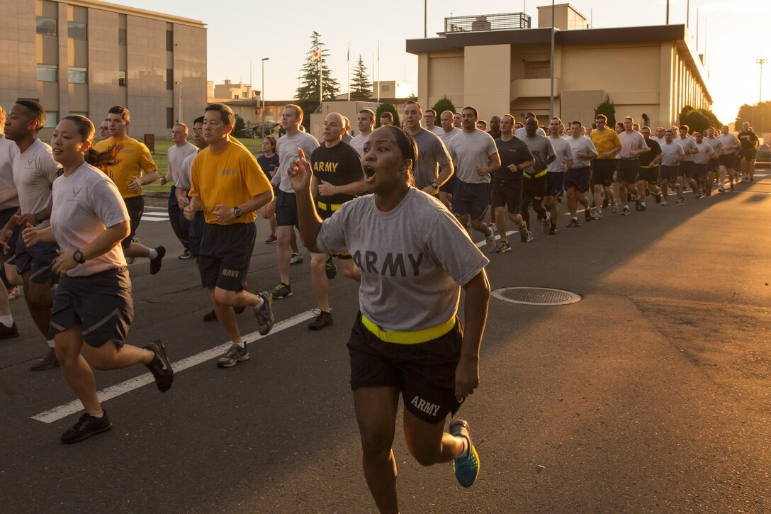 Army 1st Sgt. Donna Cook, US Forces, Japan first sergeant, shouts cadence during the USFJ Command 5K Run at Yokota Air Base, Japan, Sept. 9, 2016. Over 100 service member participated in the run, which concluded with the retirement of the old USFJ colors and the unveiling of the new USFJ colors. (U.S. Air Force photo by Yasuo Osakabe/Released) 