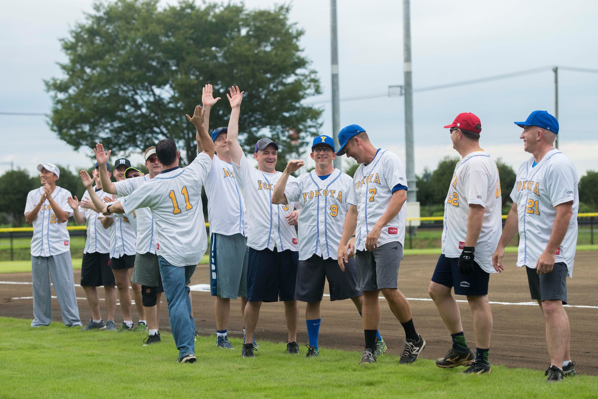 Col. Robert Dotson, 374th Operations Group commander, cheers for fellow teammates during player introductions at the grand opening of the Yokota Field baseball stadium, Sept. 9, 2016. Yokota commanders and chief master sergeants hosted a baseball game to celebrate the opening of the field. (U.S. Air Force by Senior Airman Delano Scott/Released)