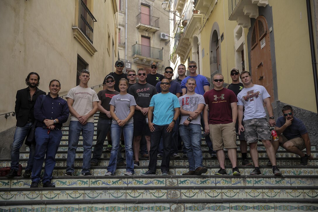 Marines with Special Purpose Marine Air-Ground Task Force Crisis Response-Africa, pose for a group photo outside the town hall in Vizzini, Sicily, Sept. 7, 2016.  Marines volunteered to clean up a local historic site and build fences during a community relations project.  (U.S. Marine Corps photo by Cpl. Alexander Mitchell/released)