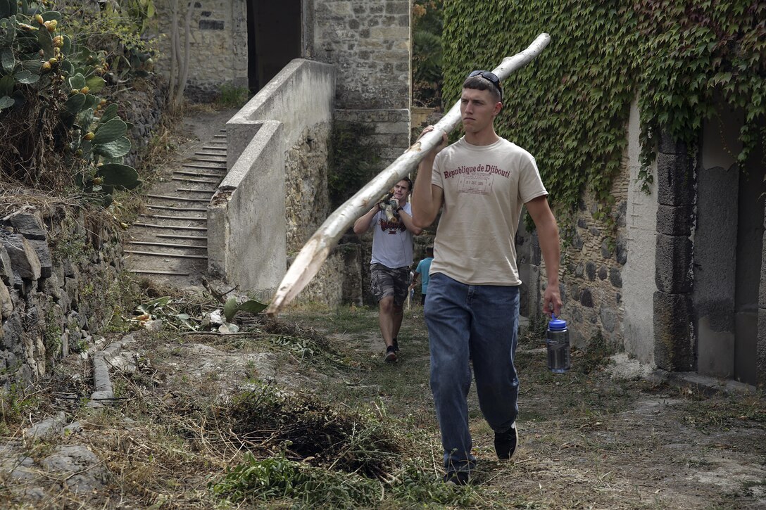 Sgt. Tyler Eskridge, a combat engineer with Special Purpose Marine Air-Ground Task Force Crisis Response-Africa, carries a fence post up a hill in Vizzini, Sicily, Sept. 7, 2016.  Marines volunteered to clean up a local historic site and build fences during a community relations project.  (U.S. Marine Corps photo by Cpl. Alexander Mitchell/released)