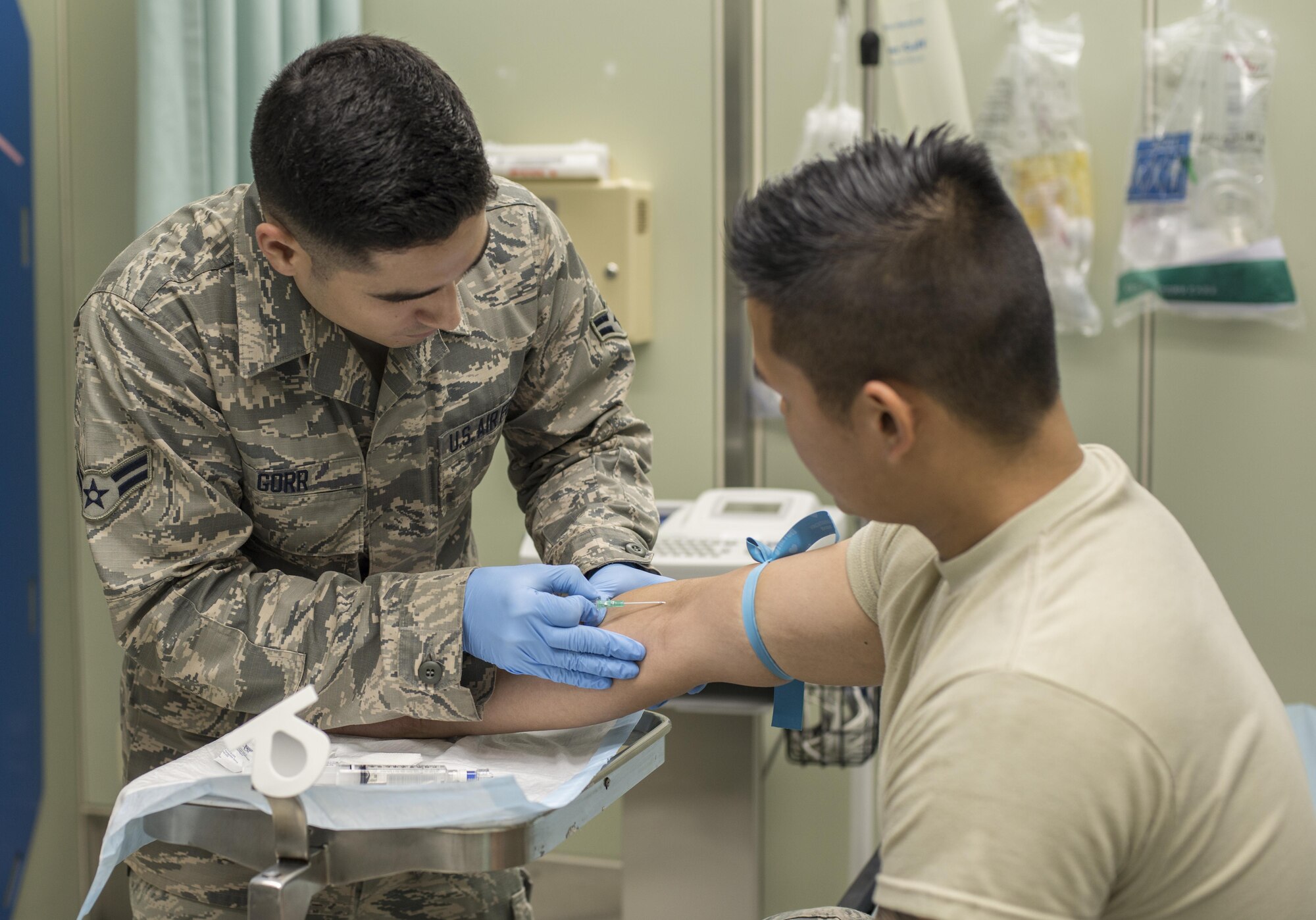 U.S. Air Force Airman 1st Class Dylan Gorr, an emergency medical technician with the 35th Medical Operations Squadron urgent care clinic, practices putting a needle into another technicians arm at Misawa Air Base, Japan, Sept. 7, 2016. Gorr assists the UCC physicians with treating everything from a cold, to stabilizing serious traumas or medical patients.(U.S. Air Force photo by Senior Airman Brittany A. Chase)