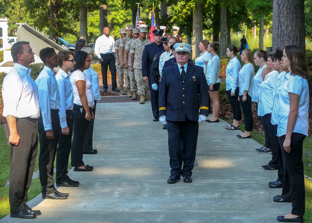 Supporters representing for the service members protecting the nation in the wake of the Sept. 11, 2001 attack, walk the path ahead of the retiring colors at the Lejeune Memorial Gardens during the Patriot Day Remembrance Ceremony on Marine Corps Base Camp Lejeune, Sept. 11, 2016. The community stood together to remember the victims of the Sept. 11, 2001 terrorist attacks during the 15 year anniversary.