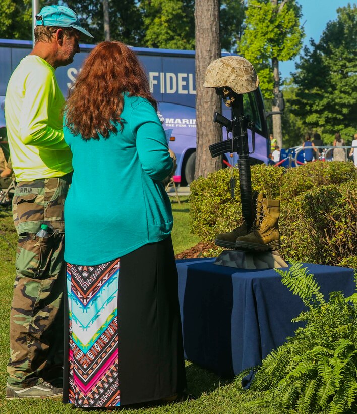 Two members of the Jacksonville community pay their respect to the representation of fallen Marines in the aftermath of the Sept. 11, 2001 attacks at the Lejeune Memorial Gardens during the Patriot Day Observance Ceremony on Marine Corps Base Camp Lejeune, Sept. 11, 2016. The community stood together to remember the victims of the Sept. 11, 2001 terrorist attacks during the 15 year anniversary.