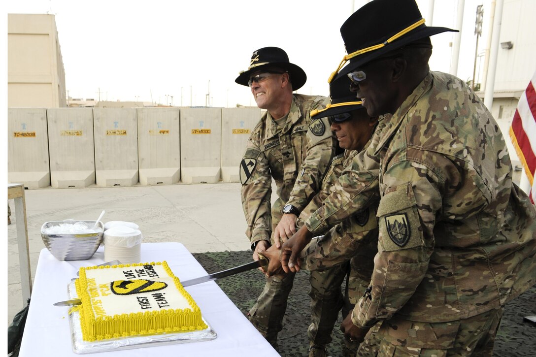 Army Maj. Gen. John .T. Thomson, commanding general,1st Cavalry Division, and Command Sgt. Maj. Maurice Jackson, 1st Cavalry Division, join the oldest and the youngest division soldiers to cut a cake commemorating the division's 95th birthday at Bagram Airfield, Afghanistan, Sept. 13, 2016. Army photo by Ben Santos