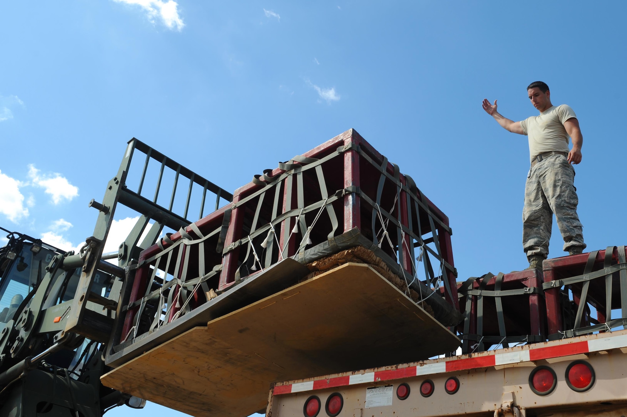 U.S Air Force Senior Airman Alexander McGowan, a 19th Logistics Readiness Squadron Aerial Delivery element member, guides a forklift delivering pallets onto a trailer after an aerial drop, Sept. 12, 2016, at a drop zone in central Arkansas. The pallets were returned to the Aerial Delivery shop to be prepared for later use. 