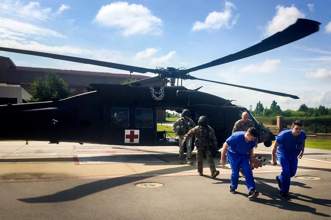 Soldiers and medical personnel transfer a simulated casualty from an HH-60 Black Hawk medevac helicopter to Womack Hospital during an exercise at Fort Bragg, N.C., Sept. 12, 2016. Army photo by Major John Houk