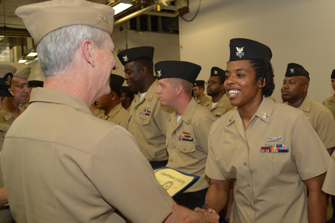 Engineman 1st Class Staci Allen shakes hands with Vice Adm. Tom Moore prior to receiving her Navy Afloat Maintenance Training Strategy (NAMTS) Certificate of Completion. Allen is a Sailor attached to Southeast Regional Maintenance Center (SERMC) in Mayport, Fla.
