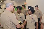 Damage Controlman 1st Class Fungai Diura shakes hands with Vice Adm. Tom Moore prior to receiving her Navy Afloat Maintenance Training Strategy (NAMTS) Certificate of Completion. Diura is a Sailor attached to Southeast Regional Maintenance Center (SERMC) in Mayport, Fla.