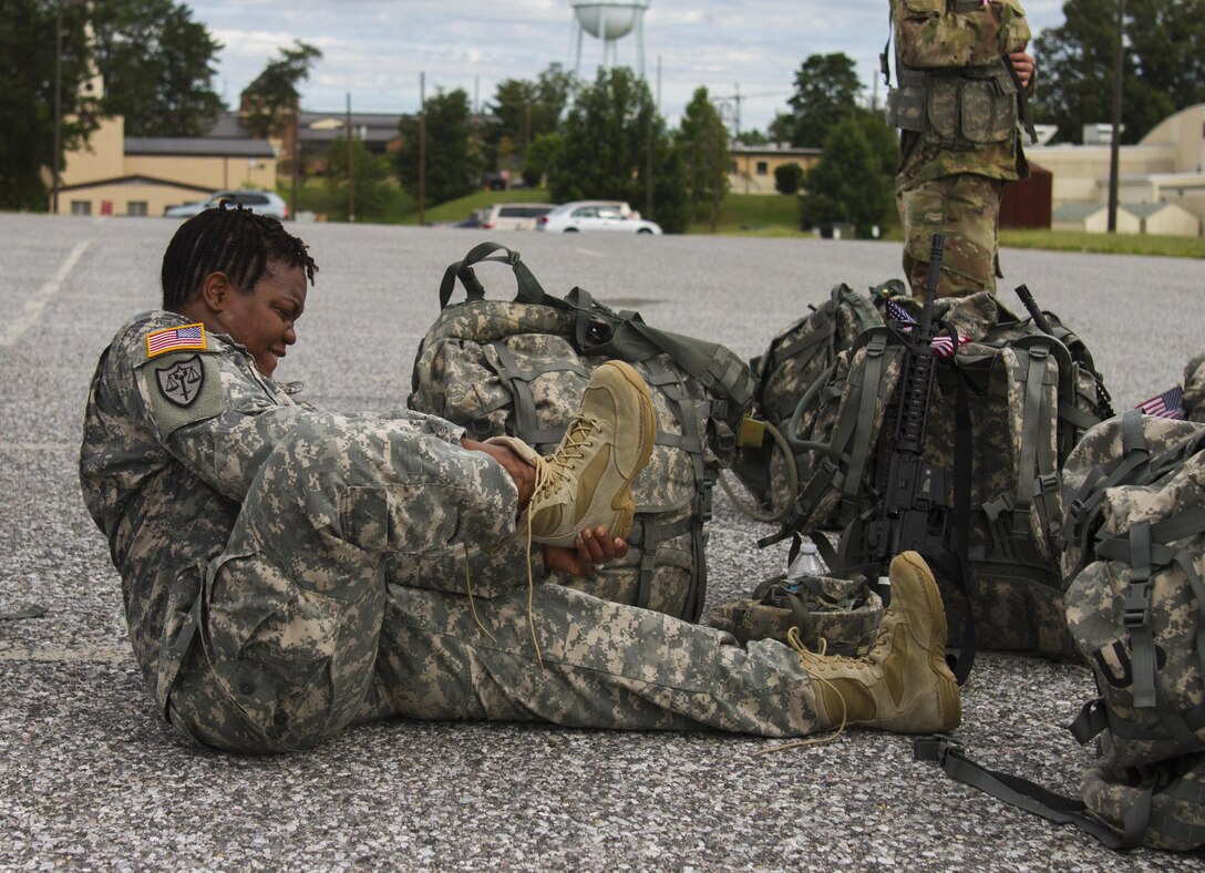 A U.S. Army Reserve Soldier assigned to the 200th Military Police Command removes her combat boots after a ruck march on Fort Meade, Md., Sept. 11, 2016. The Soldiers marched five miles with 35-pound ruck sacks. Before starting the march, the unit conducted a moment of silence in honor of those lost during 9/11 and Soldiers shared their personal memories of the attacks. (U.S. Army Reserve photo by Spc. Stephanie Ramirez)