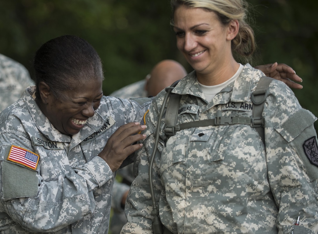 U.S. Army Reserve Spc. Linda Cook, cook, and Spc. Amber Karambellas, admin specialist, both assigned to the 200th Military Police Command, share a laugh during Army Warrior Tasks training at Laudrick Creek Military Reservation, Md., Sept. 10. The training, held during September's Battle Assembly, consisted of stations covering Chemical, Biological, Radiological, and Nuclear attack;  9-Line Medical Evacuation; search of a suspect; individual movement techniques and others. (U.S. Army Reserve photo by Staff Sgt. Shejal Pulivarti/released)