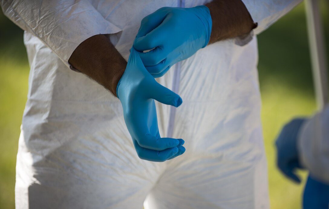 A U.S. Army Criminal Investigation Division special agent puts on a pair of gloves before processing a crime scene during Capital Shield 2016 at Fort Belvoir, Virginia, Sept. 13. Approximately 15 U.S. Army Reserve criminal investigative special agents trained alongside 25 active duty agents for the first time in a joint training exercise known as Capital Shield, focusing on crime scene processing, evidence management and hostage negotiations, held Sept. 13-15. The reserve Soldiers participating in this year's Capital Shield are agents from the 733rd Military Police Battalion (Criminal Investigation Division), headquartered in Fort Gillem, Georgia, which reports to the 200th Military Police Command. The active duty agents belong to various offices across the Washington CID Battalion, headquartered at Fort Myer, Virginia. (U.S. Army Reserve photo by Master Sgt. Michel Sauret)