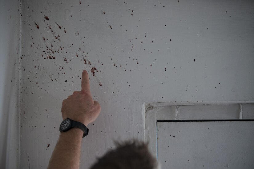 A U.S. Army special agent points to a real-blood spatter on a wall during a crime scene investigation walk-through during Capital Shield 2016 at Fort Belvoir, Virginia, Sept. 14. Approximately 15 U.S. Army Reserve criminal investigative special agents trained alongside 25 active duty agents for the first time in a joint training exercise known as Capital Shield, focusing on crime scene processing, evidence management and hostage negotiations, held Sept. 13-15. The reserve Soldiers participating in this year's Capital Shield are agents from the 733rd Military Police Battalion (Criminal Investigation Division), headquartered in Fort Gillem, Georgia, which reports to the 200th Military Police Command. The active duty agents belong to various offices across the Washington CID Battalion, headquartered at Fort Myer, Virginia. (U.S. Army Reserve photo by Master Sgt. Michel Sauret)