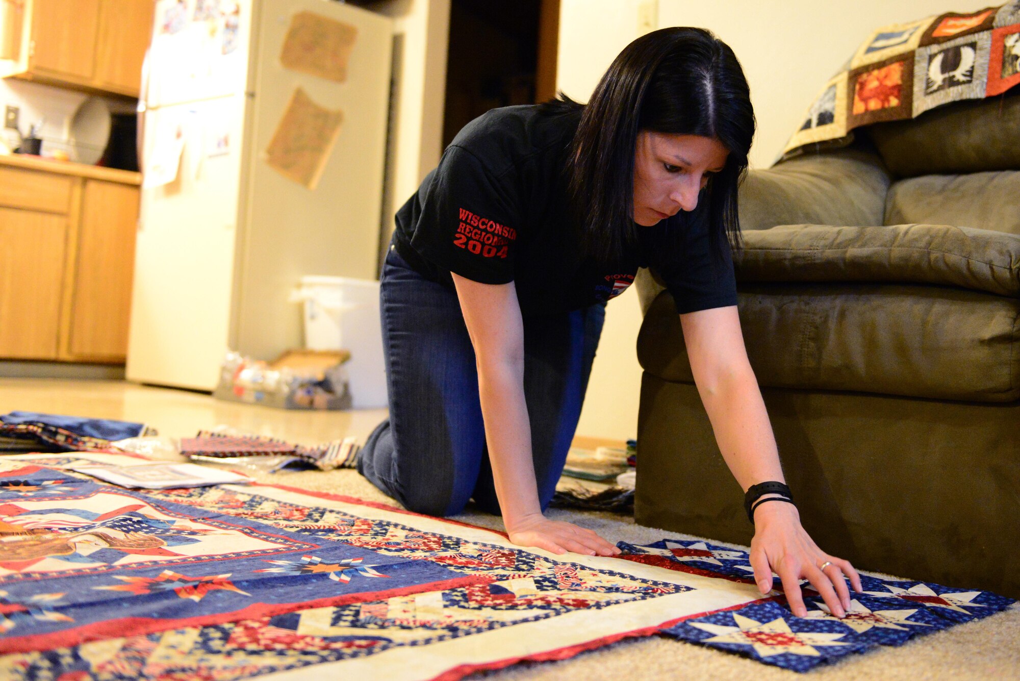 U.S. Air Force Senior Airman Karen Grinder, a 354th Contracting Squadron contracting administrator, lays pieces of cloth out for a Quilts of Valor quilt Sept. 13, 2016, at her home in North Pole, Alaska. Grinder began quilting when she was five-years-old with her grandmother who had her stitching fabric by hand. (U.S. Air Force photo by Airman 1st Class Cassandra Whitman)