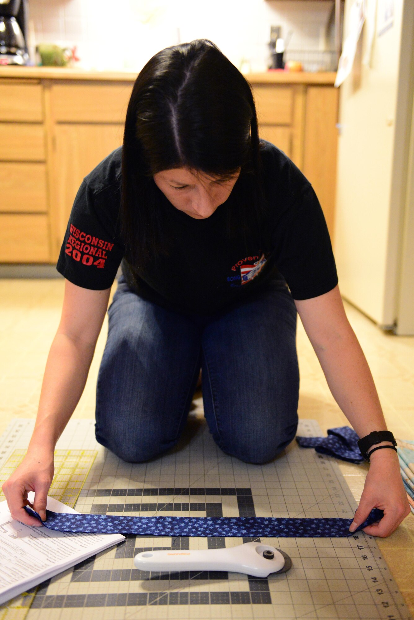 U.S. Air Force Senior Airman Karen Grinder, a 354th Contracting Squadron contracting administrator, measures a strip of fabric to cut Sept. 13, 2016, at her home in North Pole, Alaska. Grinder is working on a quilt for the Fairbanks Quilts of Valor group, which donates quilts to veterans. (U.S. Air Force photo by Airman 1st Class Cassandra Whitman)