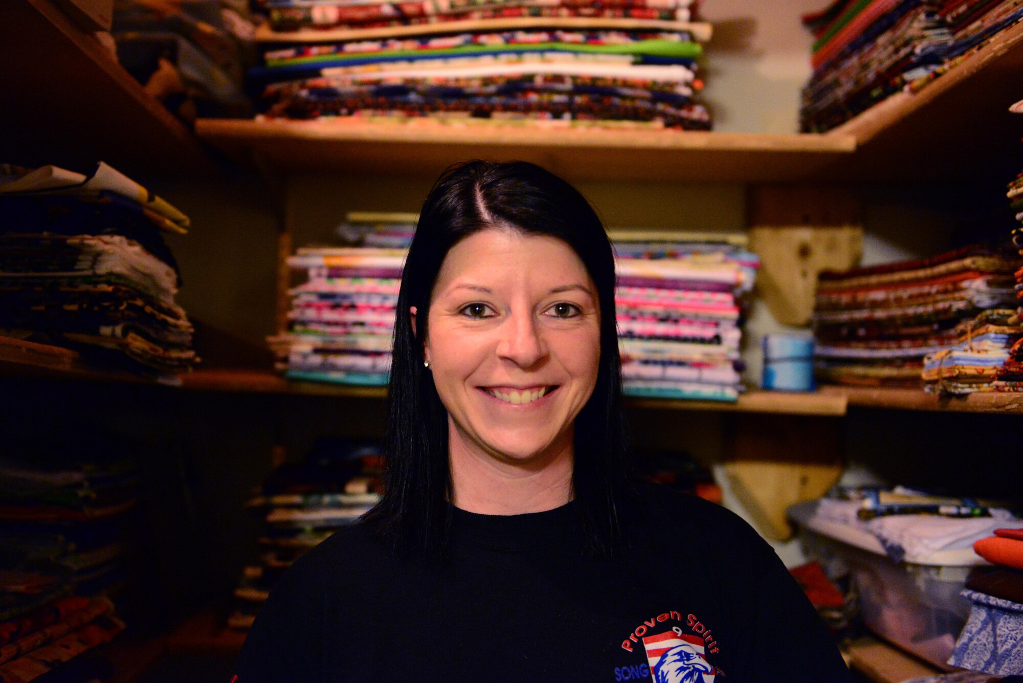 U.S. Air Force Senior Airman Karen Grinder, a 354th Contracting Squadron contracting administrator, poses for a photo Sept. 13, 2016, at her home in North Pole, Alaska. Behind her is her fabric closet, which holds roughly 1200 yards of fabric. (U.S. Air Force photo by Airman 1st Class Cassandra Whitman)
