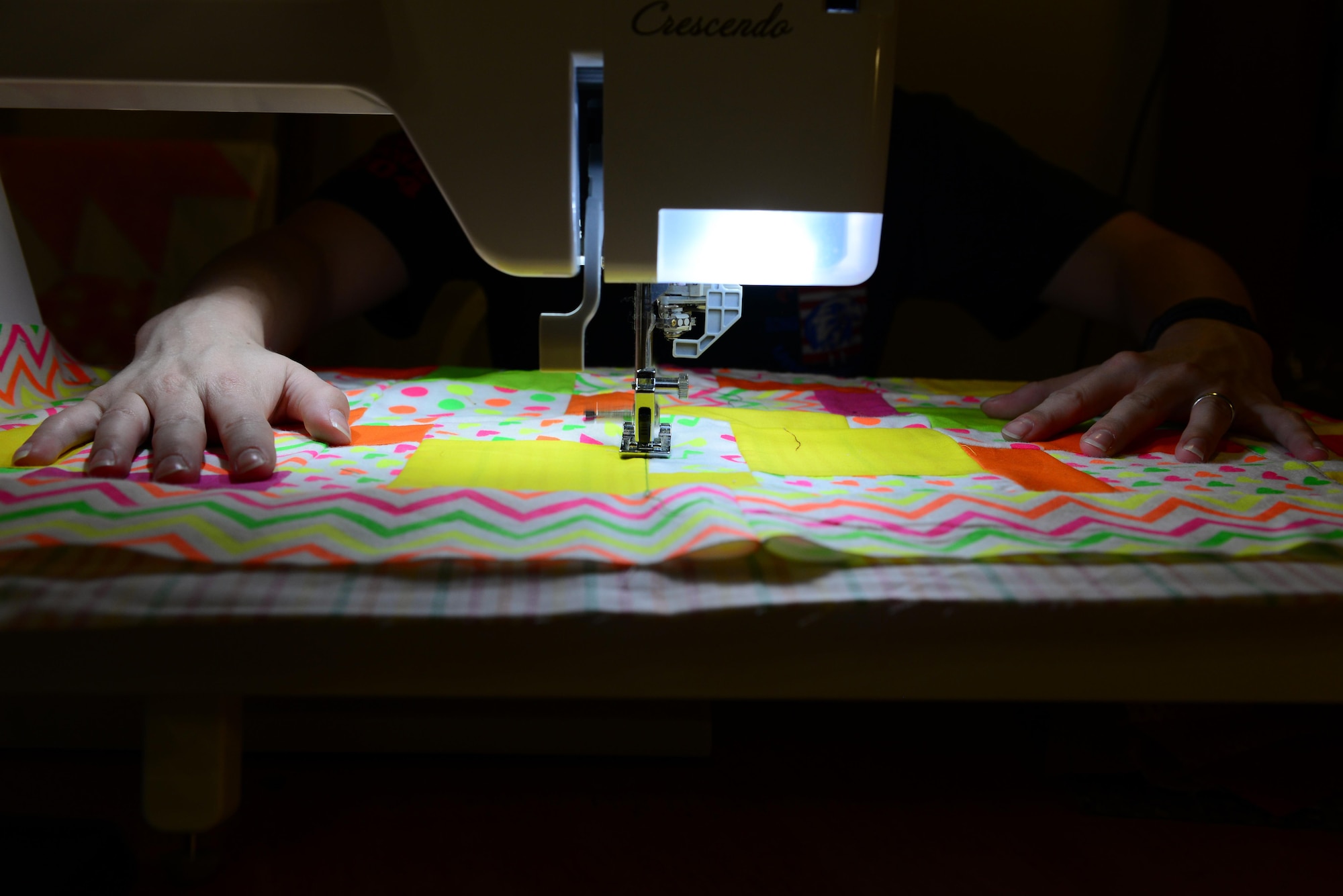 U.S. Air Force Senior Airman Karen Grinder, a 354th Contracting Squadron contracting administrator, sews fabric with a quilting machine Sept. 13, 2016, at her home in North Pole, Alaska. The machine can straight-stitch, do complex stitching patterns such as flowers and hearts, or can be used to embroider finished quilts. (U.S. Air Force photo by Airman 1st Class Cassandra Whitman)