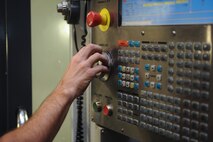Staff Sgt. Jared Henden, 2nd Maintenance Squadron Fabrication Flight aircraft metals technology journeyman, sets up the Computer Numerical Controlled machine to build a battery tie down bracket at Barksdale Air Force Base, La., Sept. 13, 2016. The CNC is programmed plans to build different parts so Airmen don’t have to create them manually. (U.S. Air Force photo/Airman 1st Class Stuart Bright)