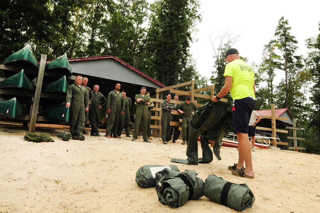 Air Force Master Sgt. William Puckett, right, instructs C-130 Hercules aircrews on the use and wear of a cold water anti-exposure suit during a water survival refresher course at Camp John J. Barnhardt, New London, N.C., Sept. 10, 2016. The suit must be donned within two minutes to prevent hypothermia. Air National Guard photo by Staff Sgt. Julianne M. Showalter