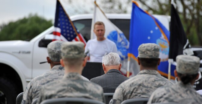 U.S. Air Force Lt. Col. (Ret.) Barry Bridger, 43rd Tactical Fighter Squadron F-4 Phantom pilot, wearing a grey suit, bows as Col. Donald Borchelt, 1st Fighter Wing vice commander, gives a speech during an opening ceremony in honor of Prisoner of War/Missing in Action Recognition Day, Sept. 15, 2016. Bridger was an aircraft commander in 1966 during a flying mission in North Vietnam, when he was shot down, captured and imprisoned for 2,232 days (six years) in North Vietnam. (U.S. Air Force photo by Tech. Sgt. Austin May)