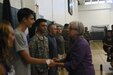ROTC students shake hands with Ambassador Isabelle Slifer after taken the oath of office for joining the Army, Army Reserve and National Guard.