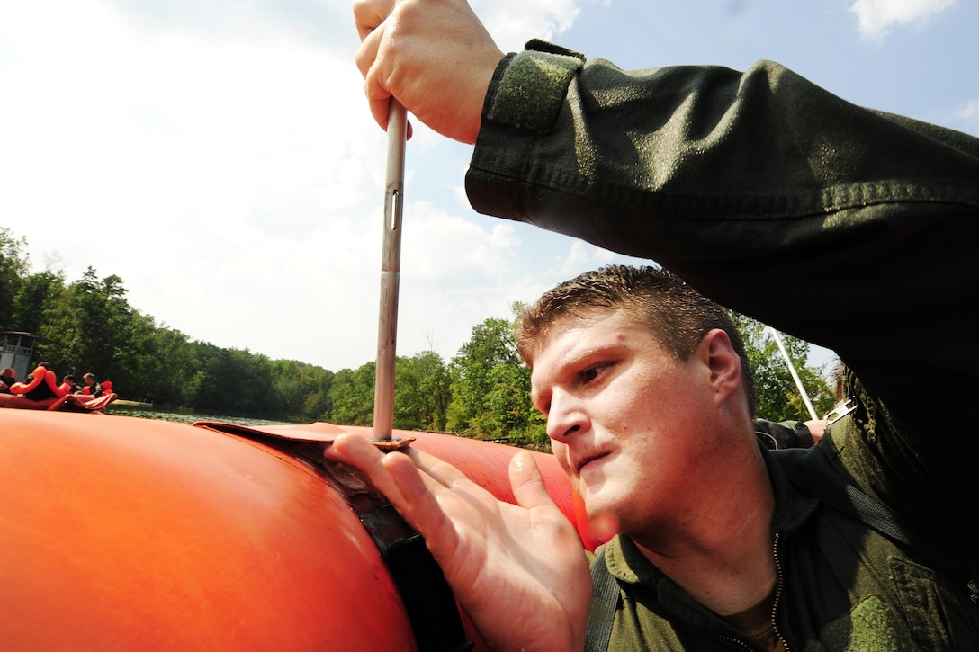 Air Force Capt. Ash Smith attaches canopy poles to a 20-man life raft during a water survival refresher course at Camp John J. Barnhardt, New London, N.C., Sept. 10, 2016. Smith is a C-130 Hercules pilot assigned to the 156th Airlift Squadron. The canopy prevents sun exposure. Air National Guard photo by Staff Sgt. Julianne M. Showalter