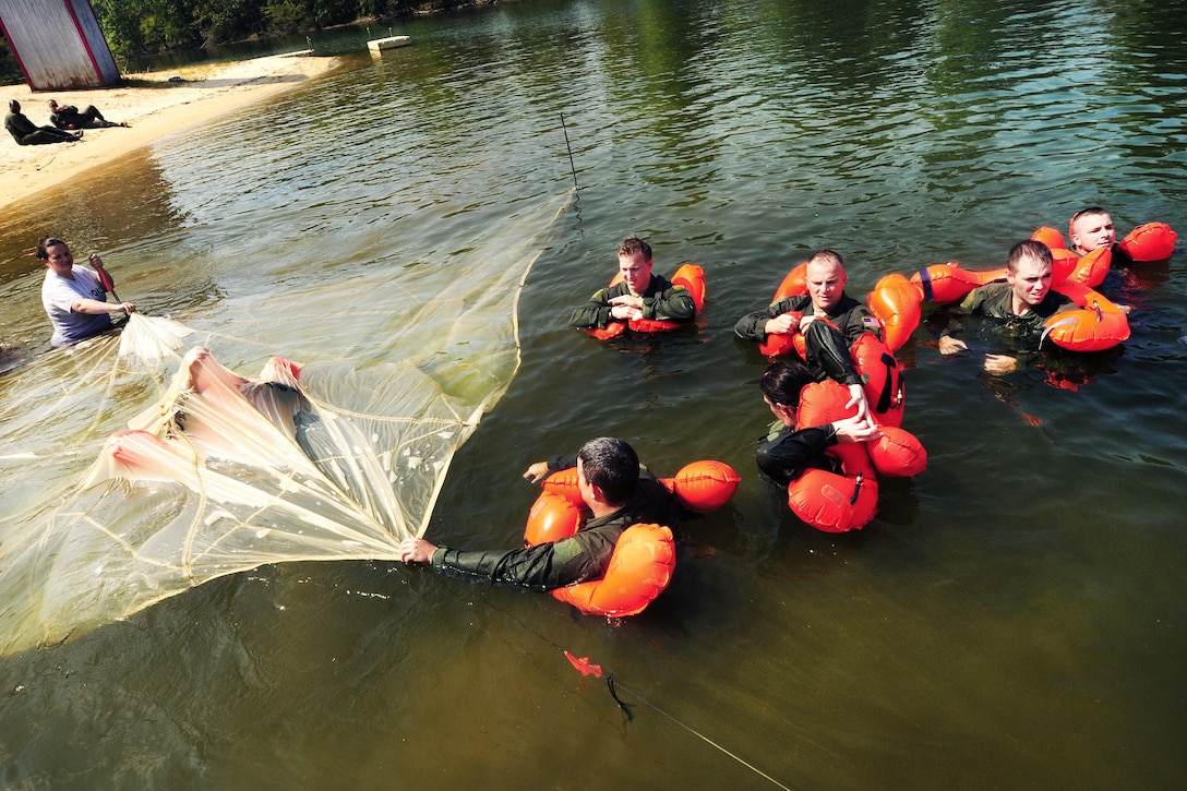 Airmen practice recovering from a parachute entanglement during a water survival refresher course at Camp John J. Barnhardt, New London, N.C., Sept. 10, 2016. During the training, aircrew members learned to create an air pocket to breathe and to free themselves by following the seams to an edge. Air National Guard photo by Staff Sgt. Julianne M. Showalter