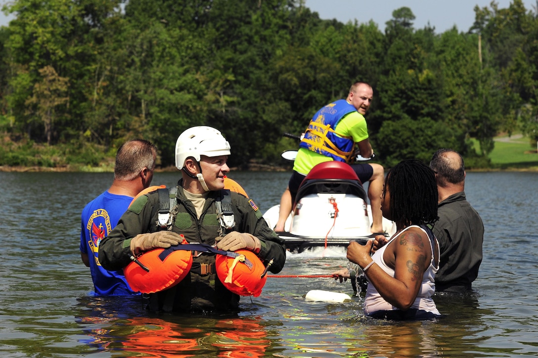 Air Force Lt. Col. Gary Dodge, left foreground, prepares for parachute quick release drills during a water survival refresher course at Camp John J. Barnhardt, New London, N.C., Sept. 10, 2016. Dodge is a pilot assigned to the 156th Airlift Squadron. The aircrew members were pulled behind a jet ski through the water to simulate being dragged by a parachute caught by the wind during a water landing. Air National Guard photo by Staff Sgt. Julianne M. Showalter