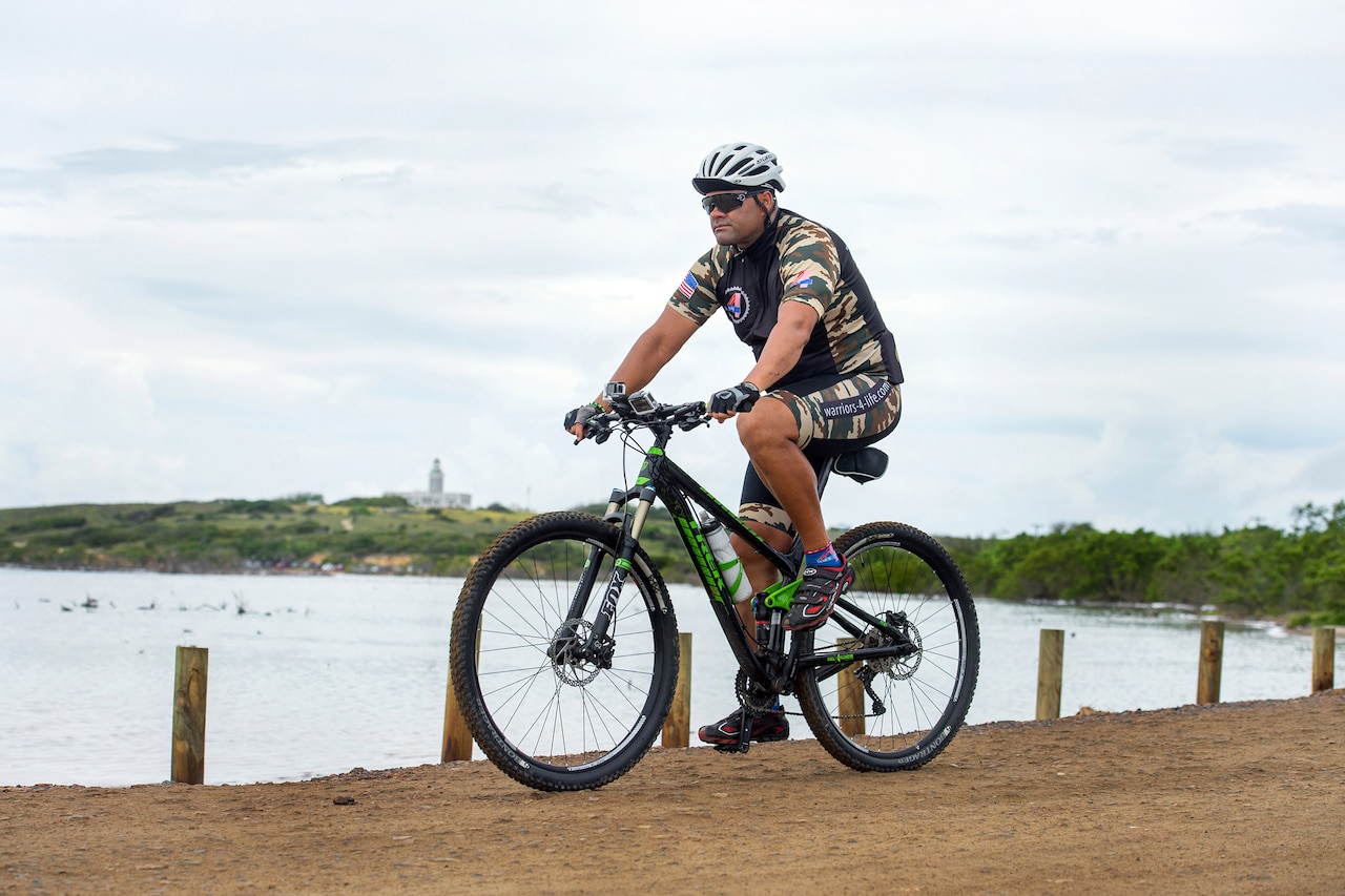 Iraqi Freedom veteran Spc. Jose E. Santiago rides a mountain bike along an oceanside road in Cabo Rojo, Puerto Rico, Aug. 13, 2016. Santiago rode in a 100-kilometer race in Puerto Rico for the Warriors 4 Life non-profit veterans group, which helps veterans cope with physical and psychological wounds and creates healthy lifestyles for them and their families. DoD photo by EJ Hersom
