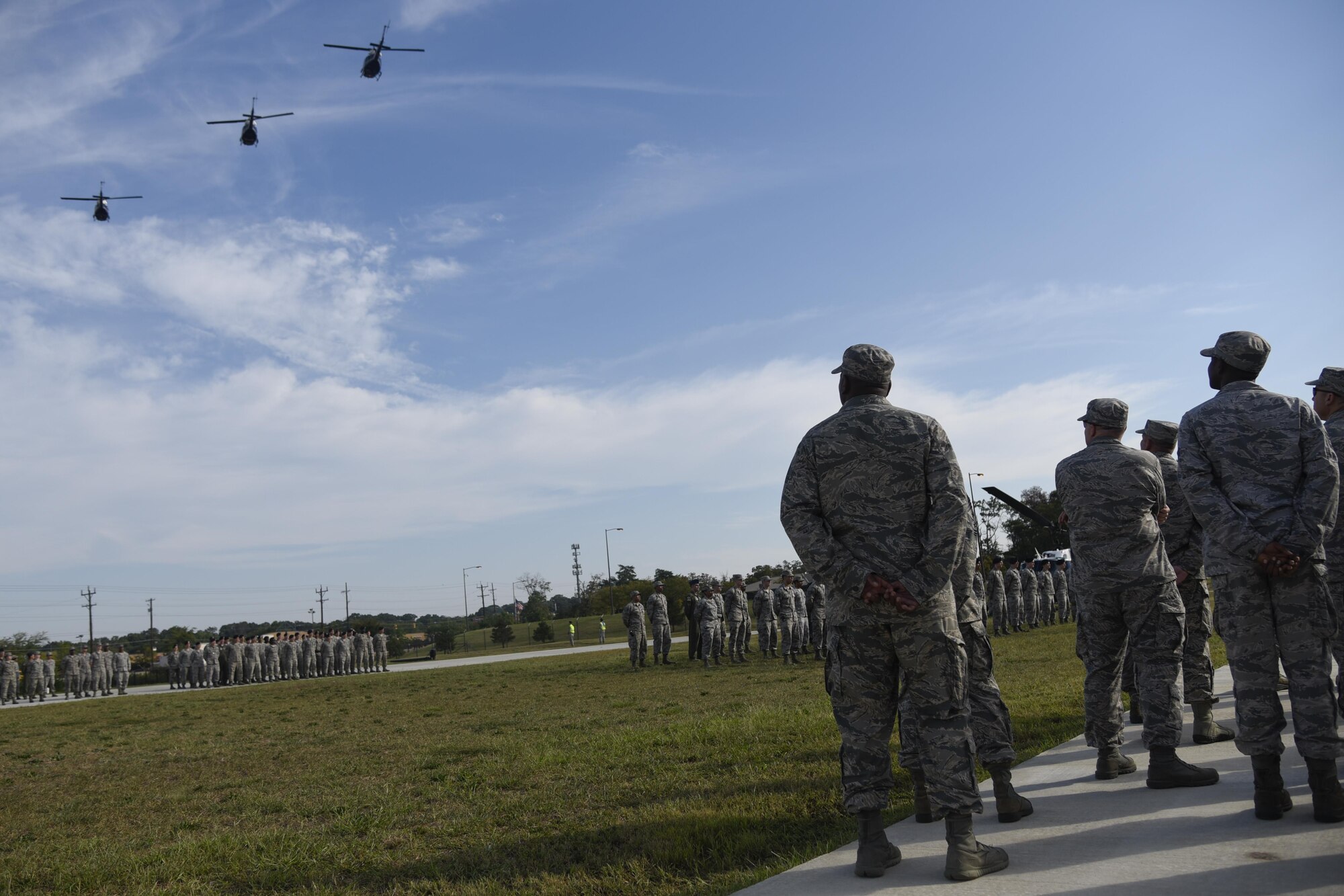 Joint Base Andrews military members observe a flyover of UH-1N Huey’s during the 9/11 Remembrance Ceremony held at Heritage Park on Joint Base Andrews, Md., Sept. 9, 2016. The ceremony paid tribute to the first responders and victims of the terrorist attacks on Sept. 11, 2001. (U.S. Air Force photo by Airman 1st Class Valentina Lopez)