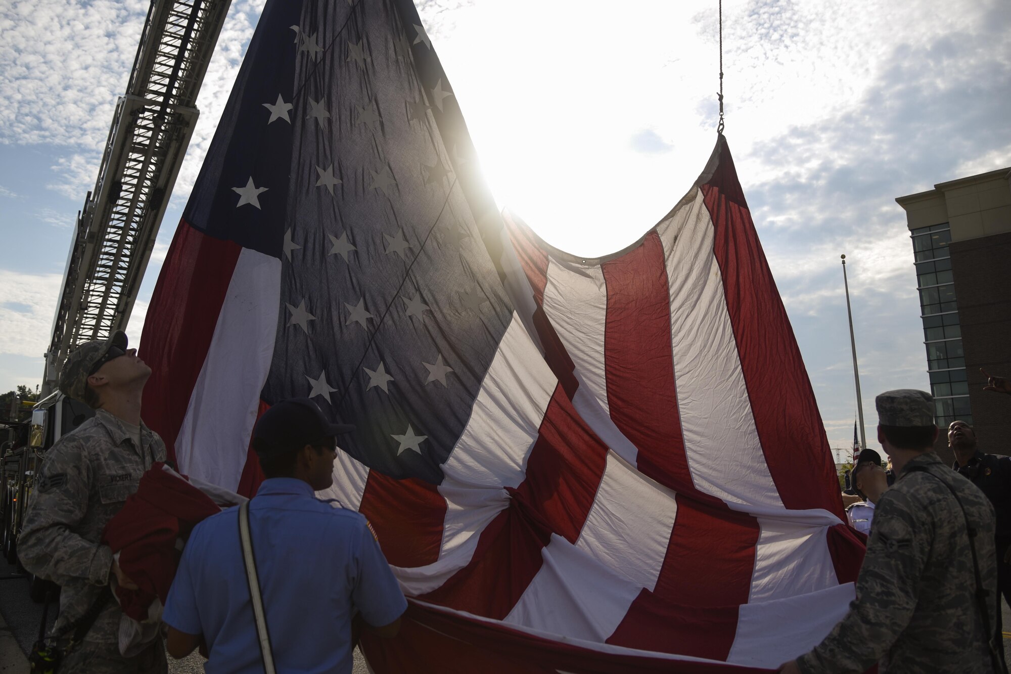 Joint Base Andrews Airmen and Prince George’s County Fire and Emergency Medical Services Department firefighters work together to raise the American flag for the 9/11 Remembrance Ceremony held at Heritage Park on Joint Base Andrews, Md., Sept 9, 2016. More than a hundred military members paid tribute to the first responders and victims of the terrorist attacks on Sept. 11, 2001, during the ceremony. (U.S. Air Force photo by Airman 1st Class Valentina Lopez)