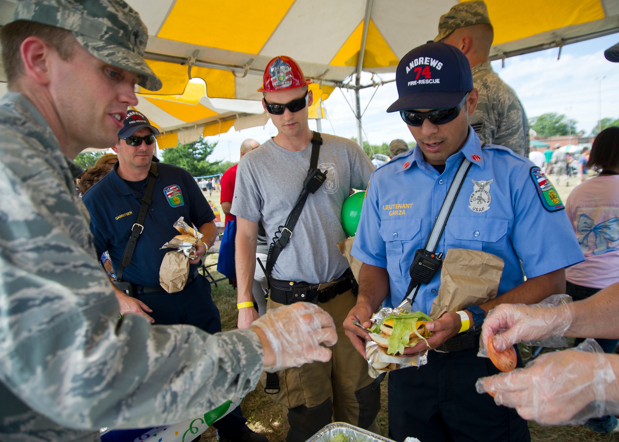 Captain Justin Woods, 459th Air Refueling Wing chaplain, serves food during Family Day at Joint Base Andrews, Maryland, Sunday, Sept. 11, 2016. The annual event featured food, sumo wrestling, volleyball, dunk tank, children’s obstacle course, softball jump castle, photo booth and much more. (U.S. Air Force photo/Staff Sgt. Kat Justen)