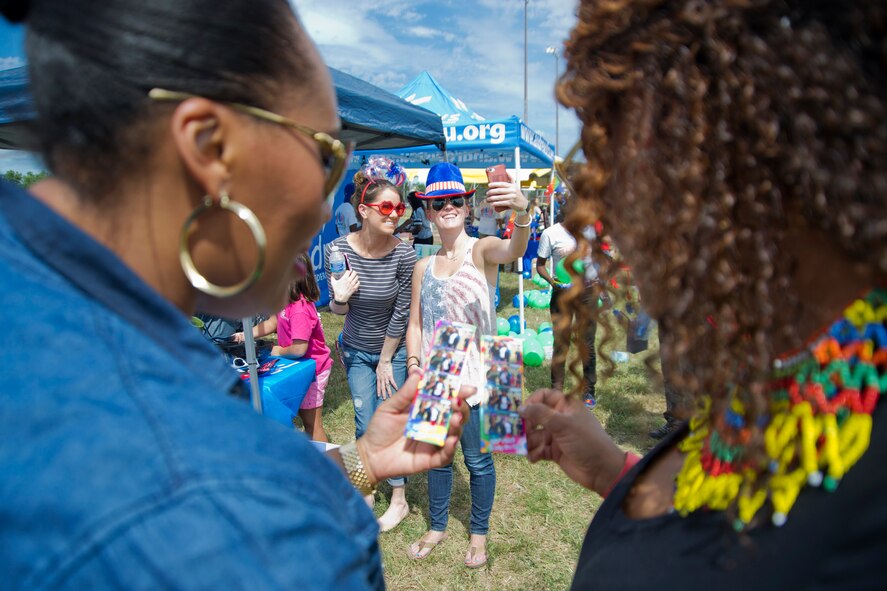 Attendees of the 459th Air Refueling Wing Family Day look at photos and pose for selfies at the photo booth at Joint Base Andrews, Maryland, Sunday, Sept. 11, 2016. The annual event featured food, sumo wrestling, volleyball, dunk tank, children’s obstacle course, softball jump castle, photo booth and much more. (U.S. Air Force photo/Staff Sgt. Kat Justen)