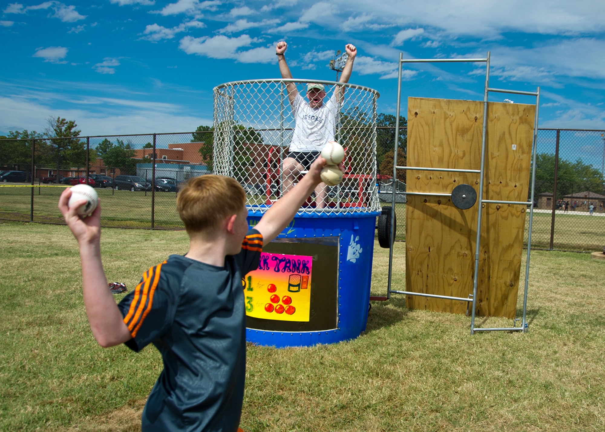 A 459th Air Refueling Wing dependent prepares to throw a baseball at the dunk tank as 459th ARW commander Col. David Owens prepares for the challenge during Family Day at Joint Base Andrews, Maryland, Sunday, Sept. 11, 2016. The annual event featured food, sumo wrestling, volleyball, dunk tank, children’s obstacle course, softball jump castle, photo booth and much more. (U.S. Air Force photo/Staff Sgt. Kat Justen)
