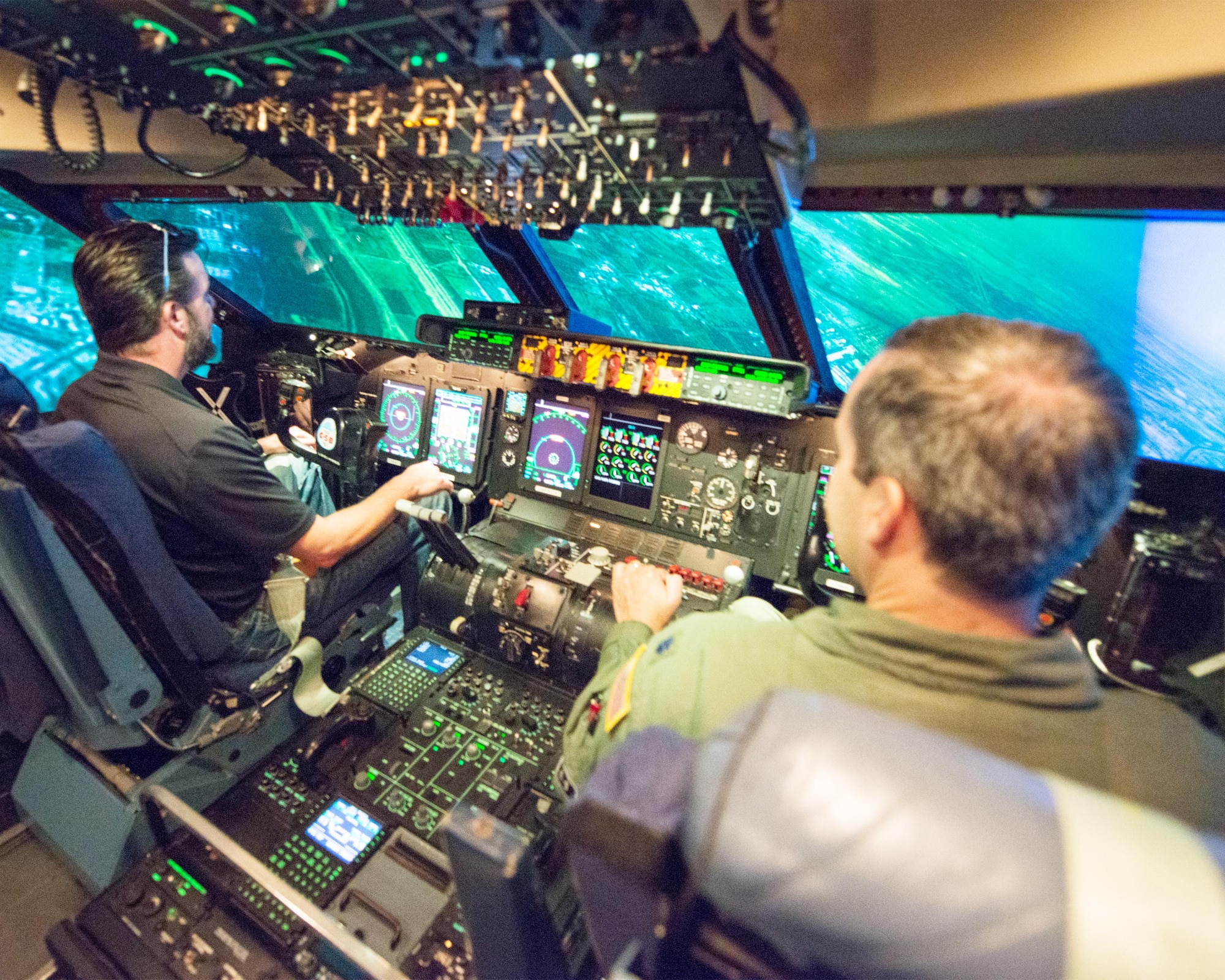 U.S. Air Force Lt. Col. Rich Linton, 22nd Airlift Squadron director of operations, Travis Air Force Base, Calif., assists Honorary Commander Michael Warrell during the C-5 Galaxy simulator flight, Sep. 9, 2016. (U.S. Air Force photo by Louis Briscese)