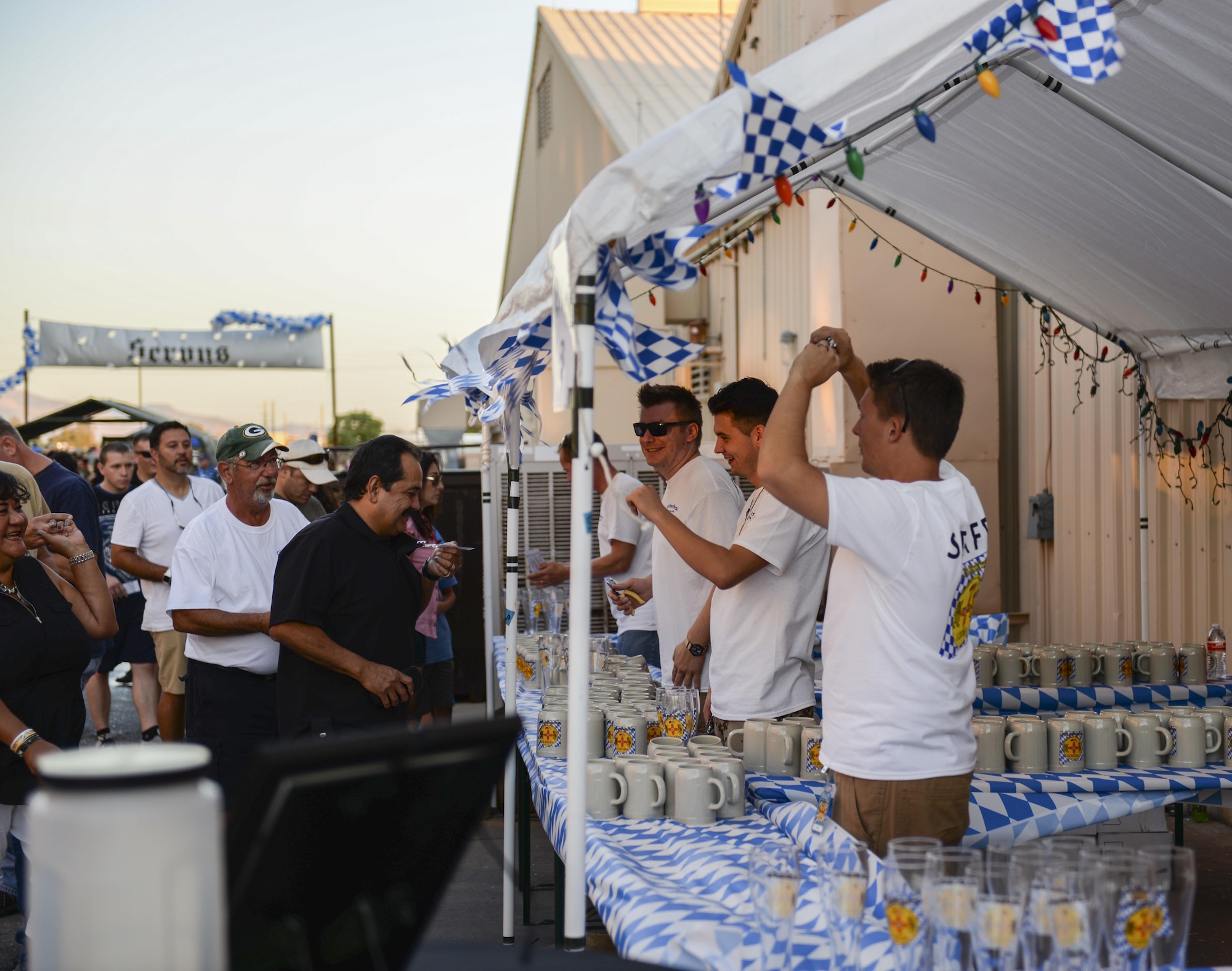 Oktoberfest staff sell beer steins and glasses to attendees at the fest’s main entrance during the 20th annual Oktoberfest at Holloman Air Force Base, N.M. on Sept. 10, 2016. Attendees of this year’s Oktoberfest enjoyed traditional Bavarian foods, beer and fun activities. (U.S. Air Force photo by Airman Alexis P. Docherty) 