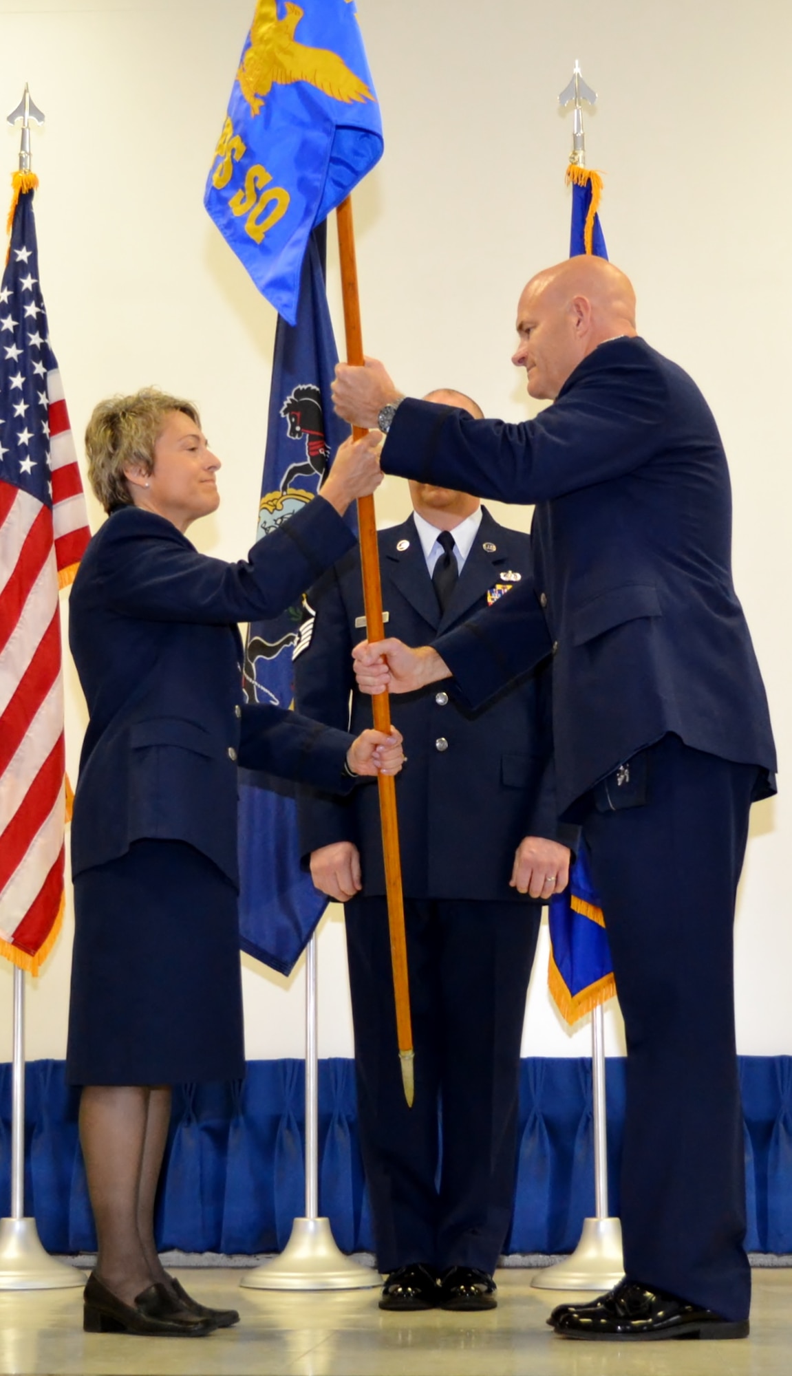 Lt. Col. Claudia Malone, 112th Cyberspace Operations Squadron commander, takes the guidion from Col. Michael Shenk, 111th Operations Group commander, during her assumption of command held at the 111th Attack Wing headquarters building here Sept. 10, 2016. Afterwards, as the first-ever 112th COS commander, she described the evolution of the cyberspace field over the past 50 years, and with a bit of humor, projected where it would be in the future. (U.S. Air National Guard photo by Tech. Sgt. Andria Allmond)