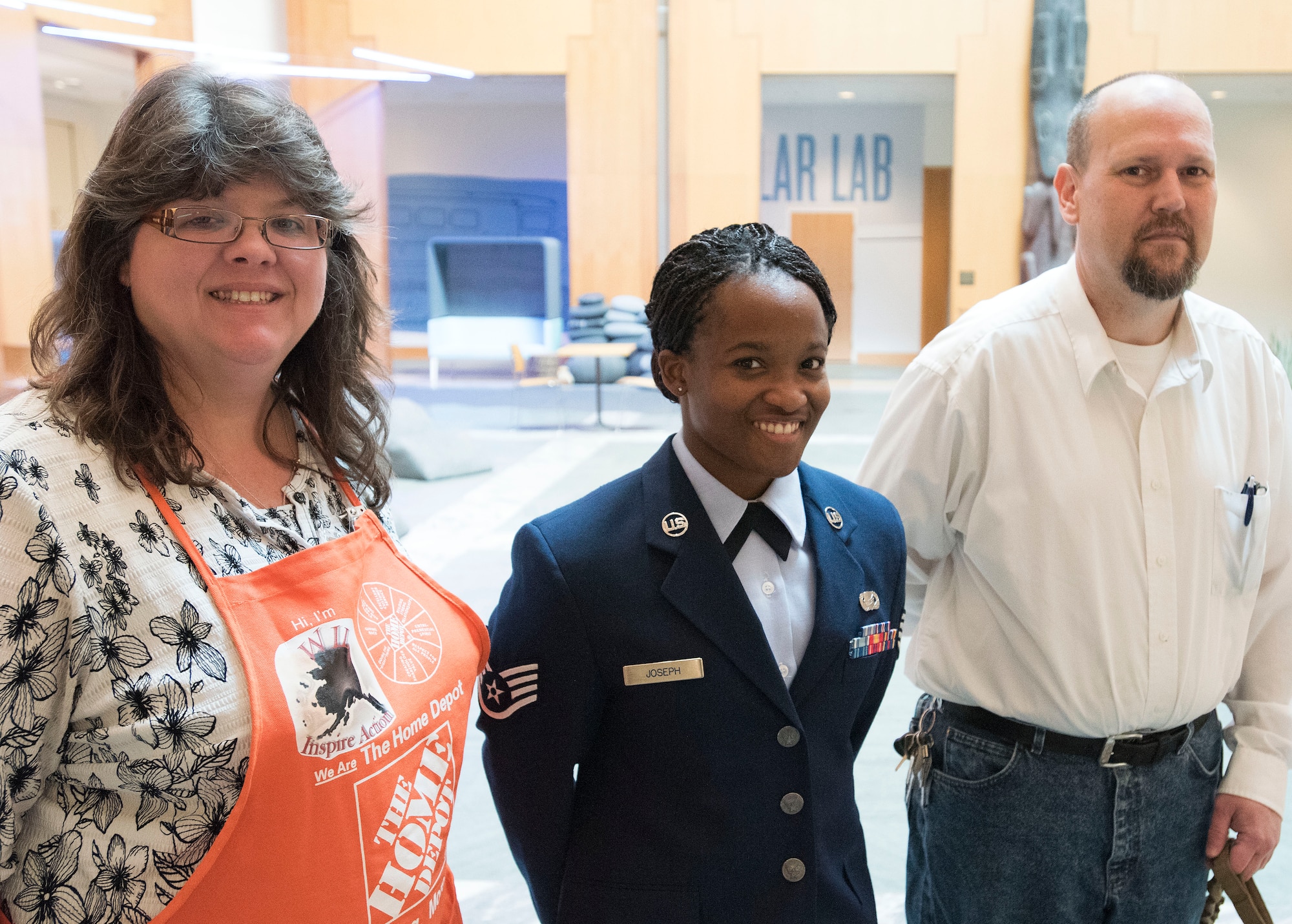 ANCHORAGE, Alaska -- Staff Sgt. Sequoya Joseph, a personnelist with the Alaska Air National Guard's 176th Force Support Flight, is pictured at the Anchorage Museum here Sept. 14, 2016, with Home Depot Alaska District Human Resources Manager Patty St. John and Jake Bainbridge, a therapy dog coordinator with Midnight Sun Service Dogs. Joseph was at the museum to honored for her service. More than 50 volunteers came together to renovate Sgt. Joseph's condominium. The event was the result of a partnership between Home Depot's annual Celebration of Service Campaign and the non-profit That Others May Live Foundation. National Guard photo by Maj. John Callahan.