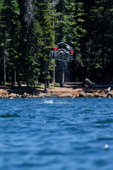 Oregon Air National Guard Capt. Nathan Liptak, 114th Fighter Squadron pilot, sits in a basket loaded by Aviation Survival Technician 3rd Class Brendan Davis, Coast Guard Sector North Bend, during water survival training at Lake of the Woods near Klamath Falls, Ore., July 22, 2016. Aircrew Flight Equipment members joined with Klamath County Sheriff's Department agencies and members of Coast Guard Sector North Bend to provide Kingsley’s F-15 pilots water survival training in the event of an emergency ejection. (U.S. Air National Guard photo by Staff Sgt. Penny Snoozy)